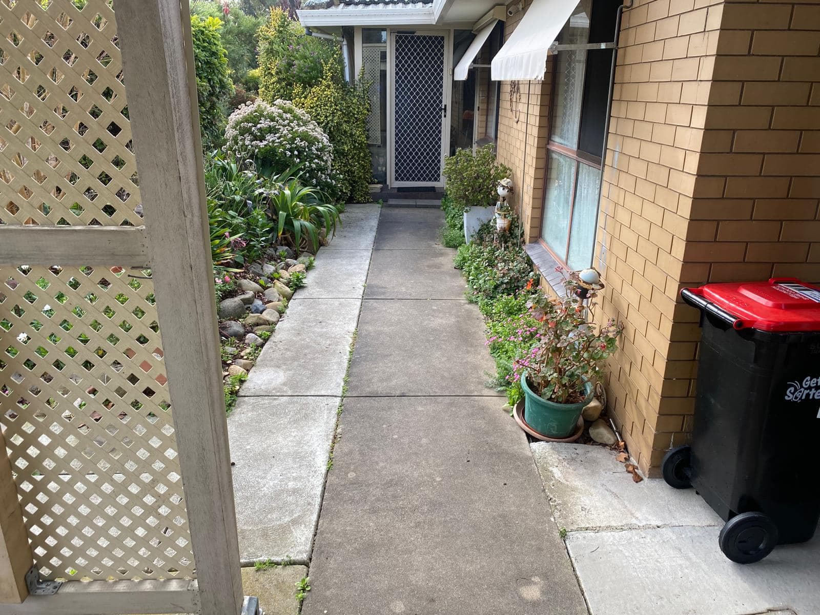 Worn concrete path before charcoal resurfacing
